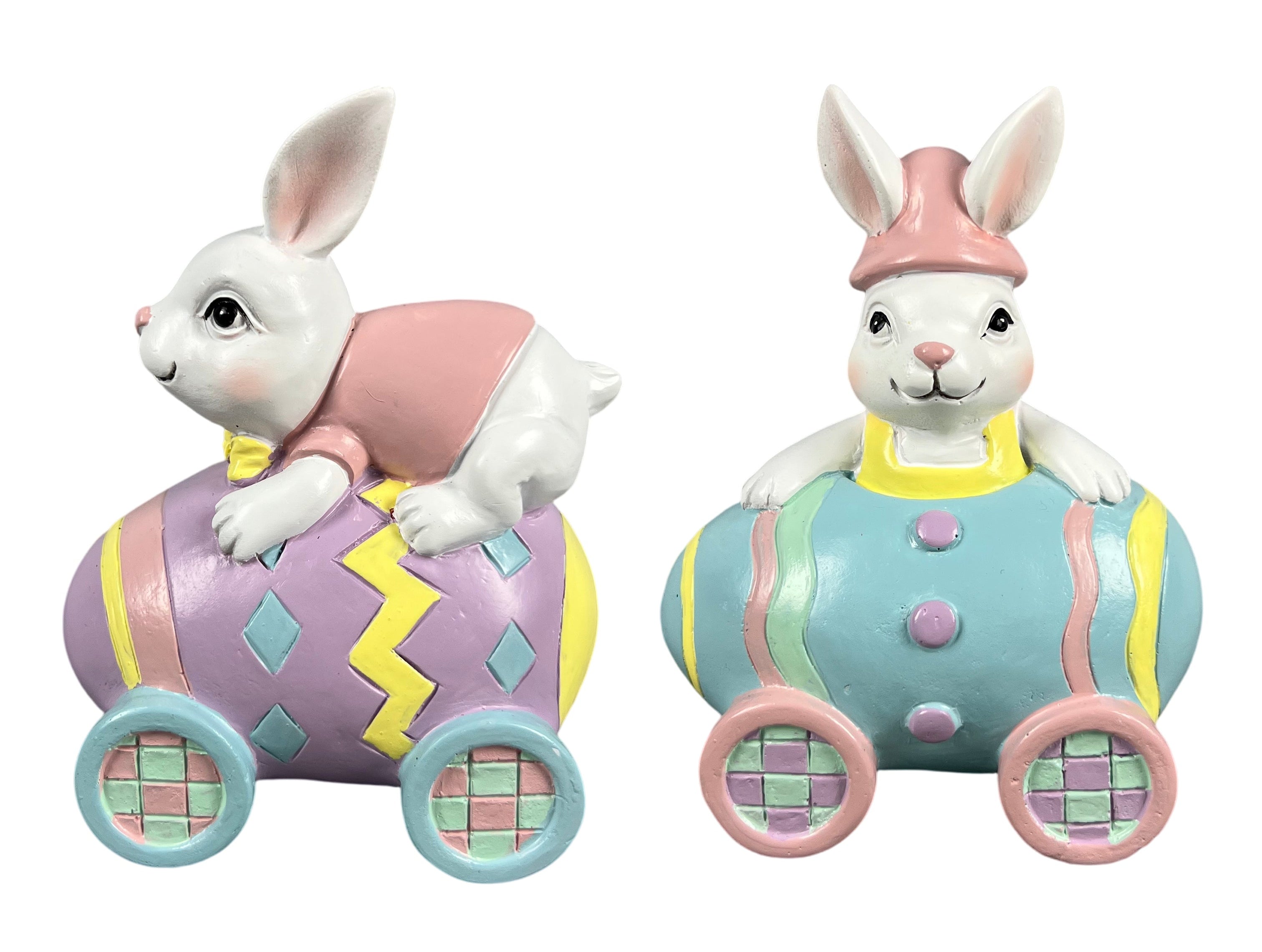 Two Easter bunny figurines sitting on pastel-colored egg cars.