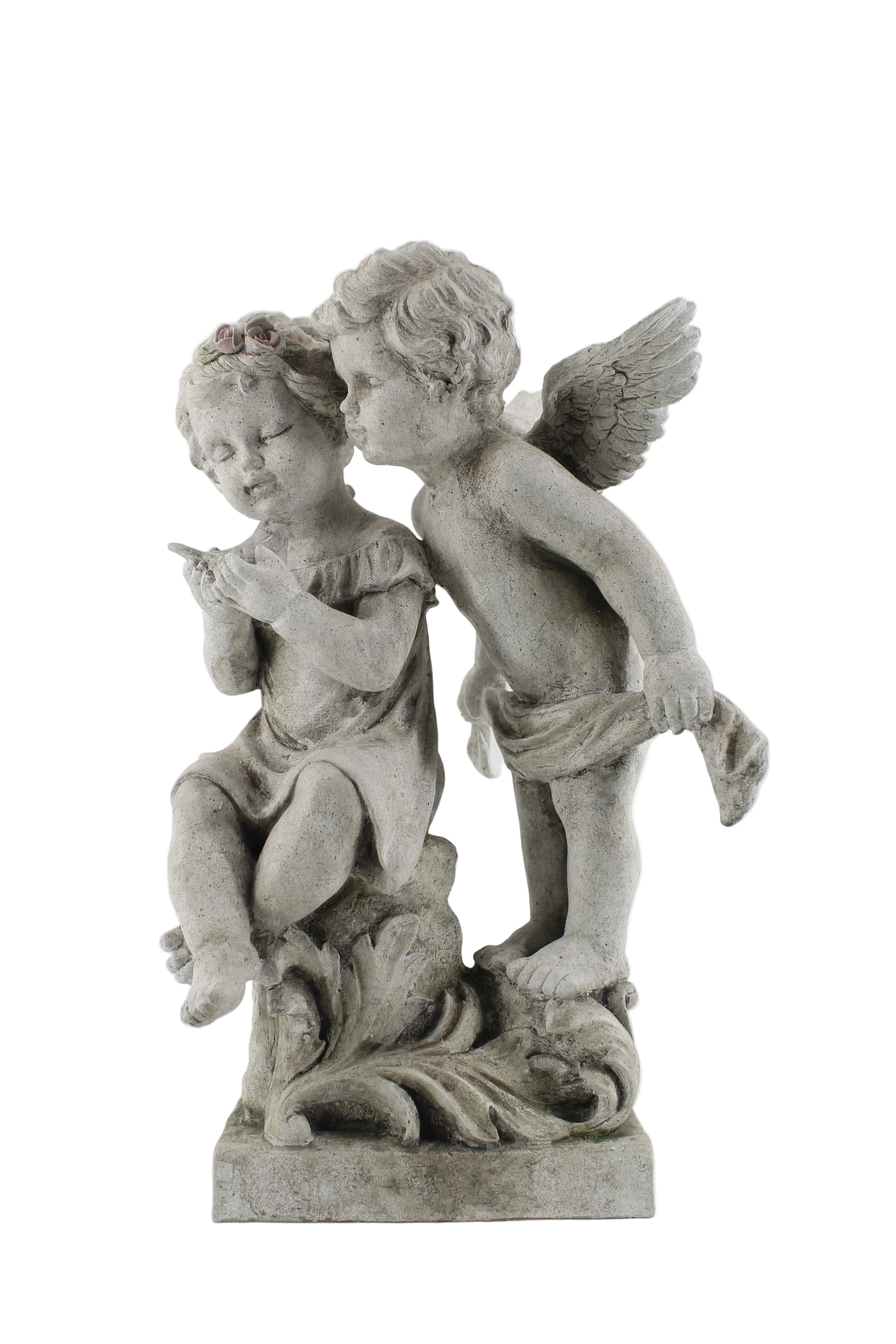 A gray stone or concrete sculpture of two cherubs, one seated and one standing, on a decorative leafy base