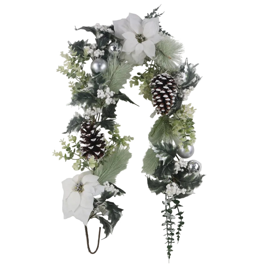 An artificial Christmas garland with white poinsettias, green and white holly leaves, pinecones, and silver ornaments.