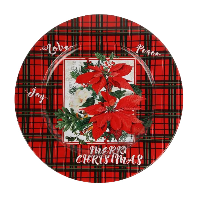 A round decorative metal plate with a red and black plaid pattern, featuring a central holiday design with red poinsettias, green holly leaves, white snowdrops, and white script text reading 'Merry Christmas' and 'Joy'.