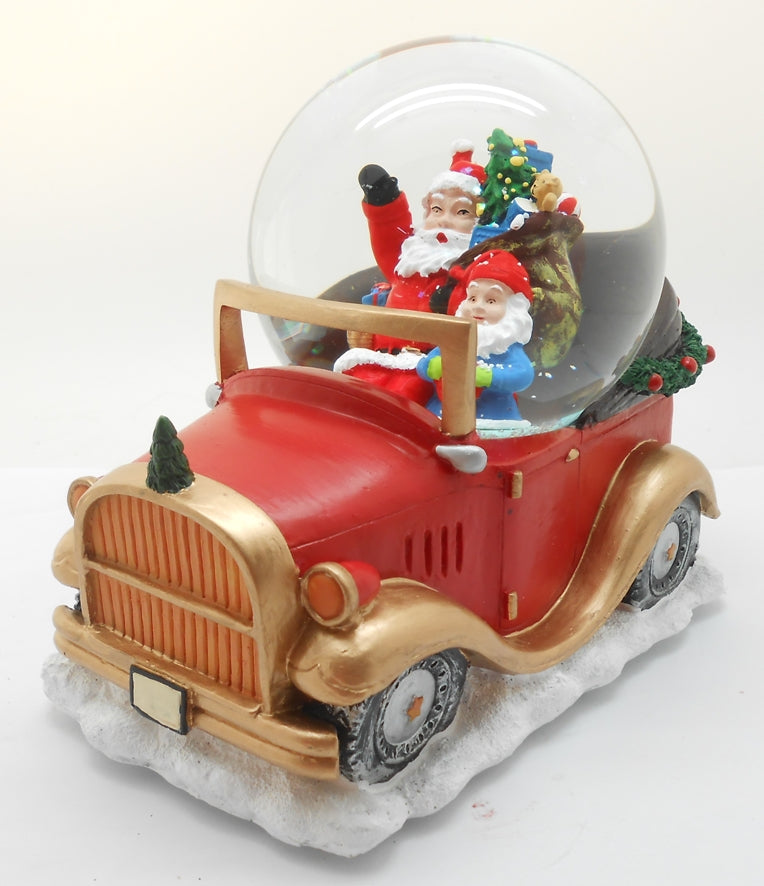 A decorative snow globe featuring Santa Claus sitting in a red and gold toy car with a Christmas tree.