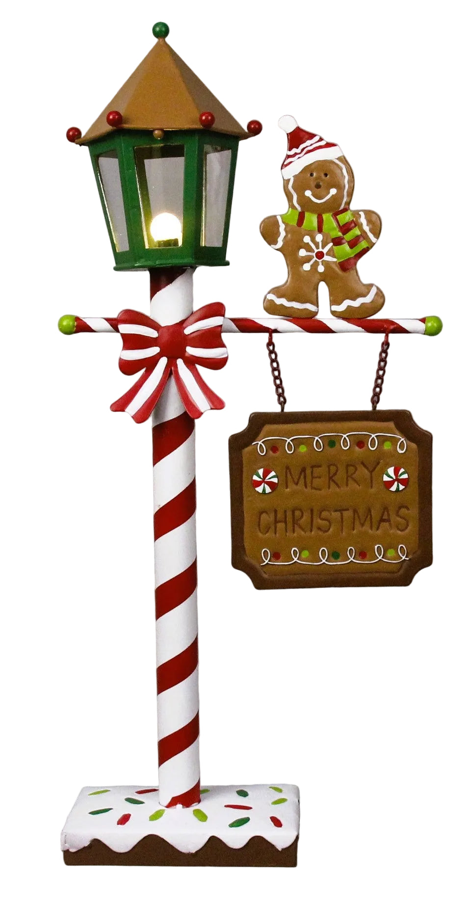 A decorative lamppost featuring a gingerbread man in a Santa hat and a 'Merry Christmas' sign, with a green top and red and white candy cane striped pole.