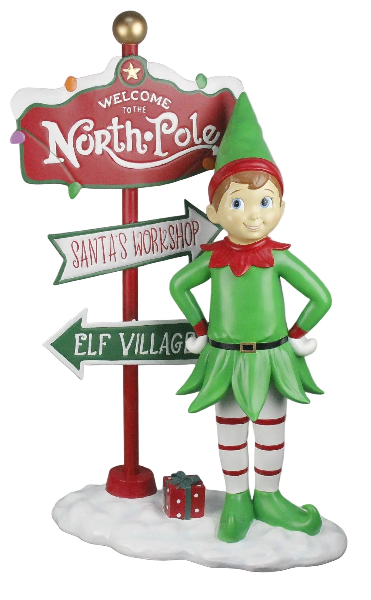 A decorative figurine of an elf with a green, red and white outfit, standing on a snow base next to a sign post.
