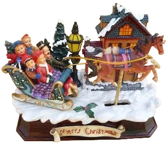 A 6 inch musical box depicting a family in Christmas attire, with children sitting in a sleigh being pulled by a horse, and a decorated house in the background. The base has 'Merry Christmas' written on it.