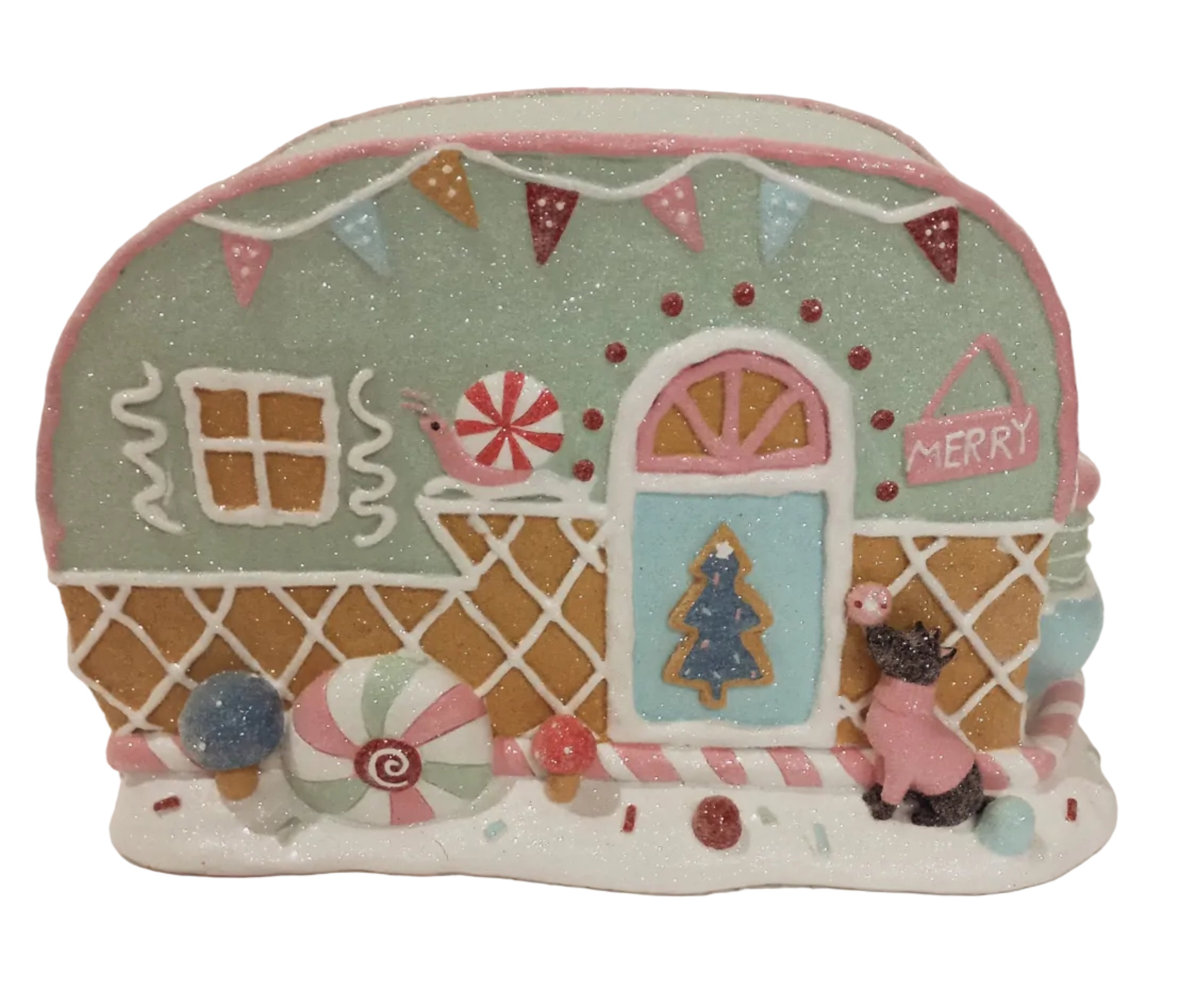 A decorative gingerbread caravan with holiday ornaments, featuring a green house with pink accents, a white door, and a sign that reads 'Merry'. There are also candy canes and a dog figure present.