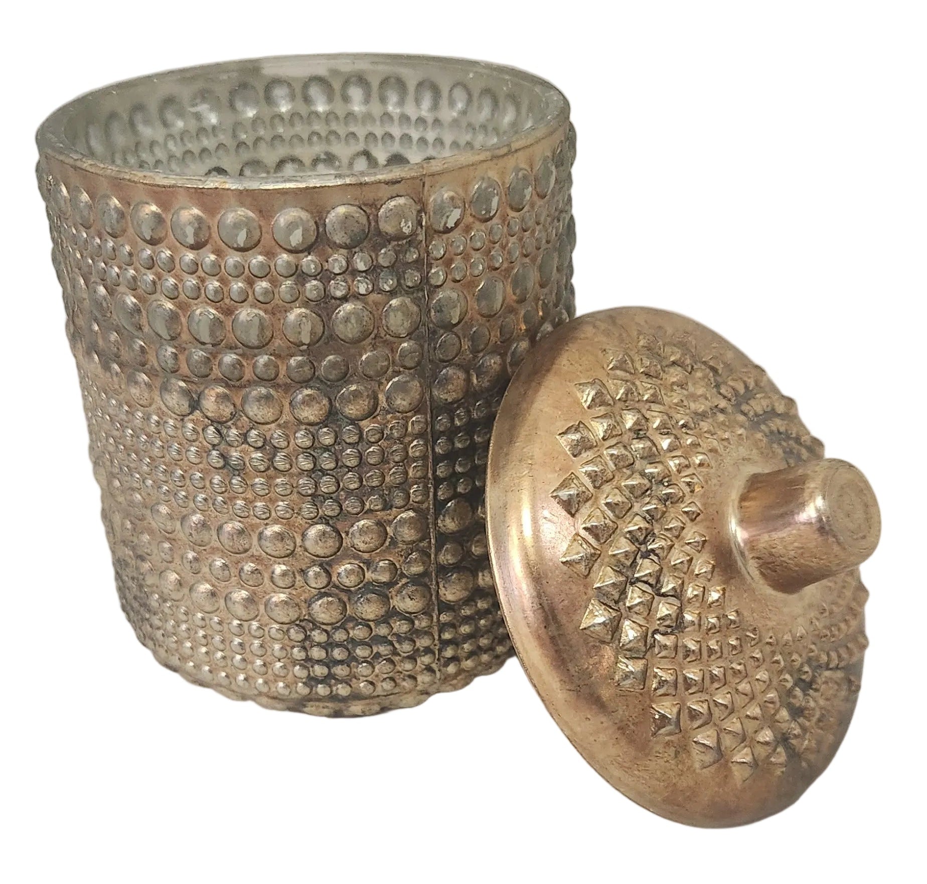 Decorative metal container with textured surface and candle