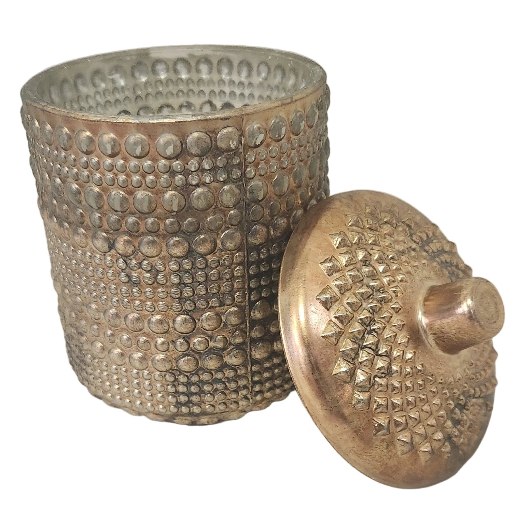 Decorative metal container with  textured surface and lid on a light gray background