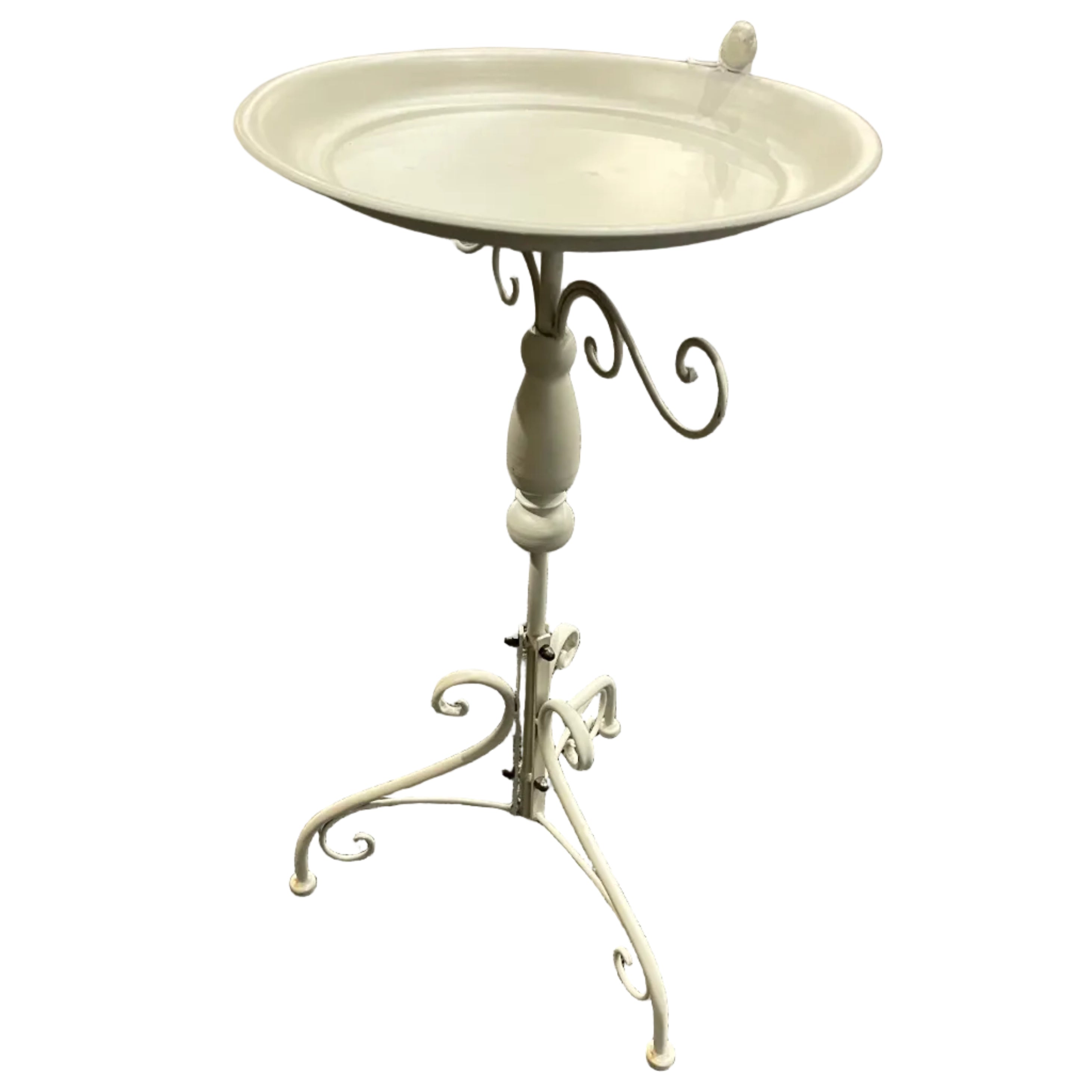 A white metal pedestal bird bath with a shallow round tray and ornate scrollwork legs