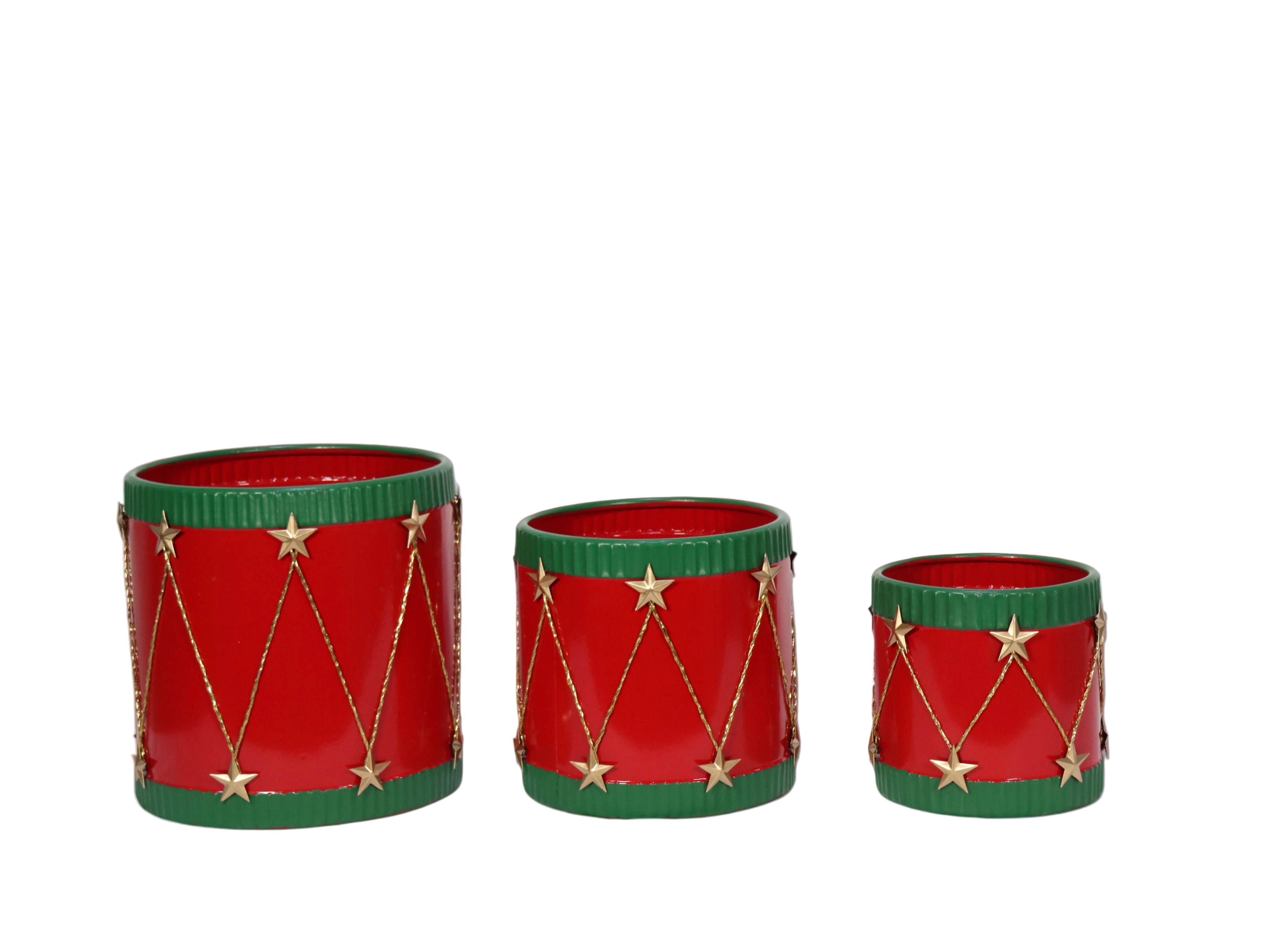Three red and green drum-shaped candle holders with gold star details, arranged in a size gradient from left to right. 