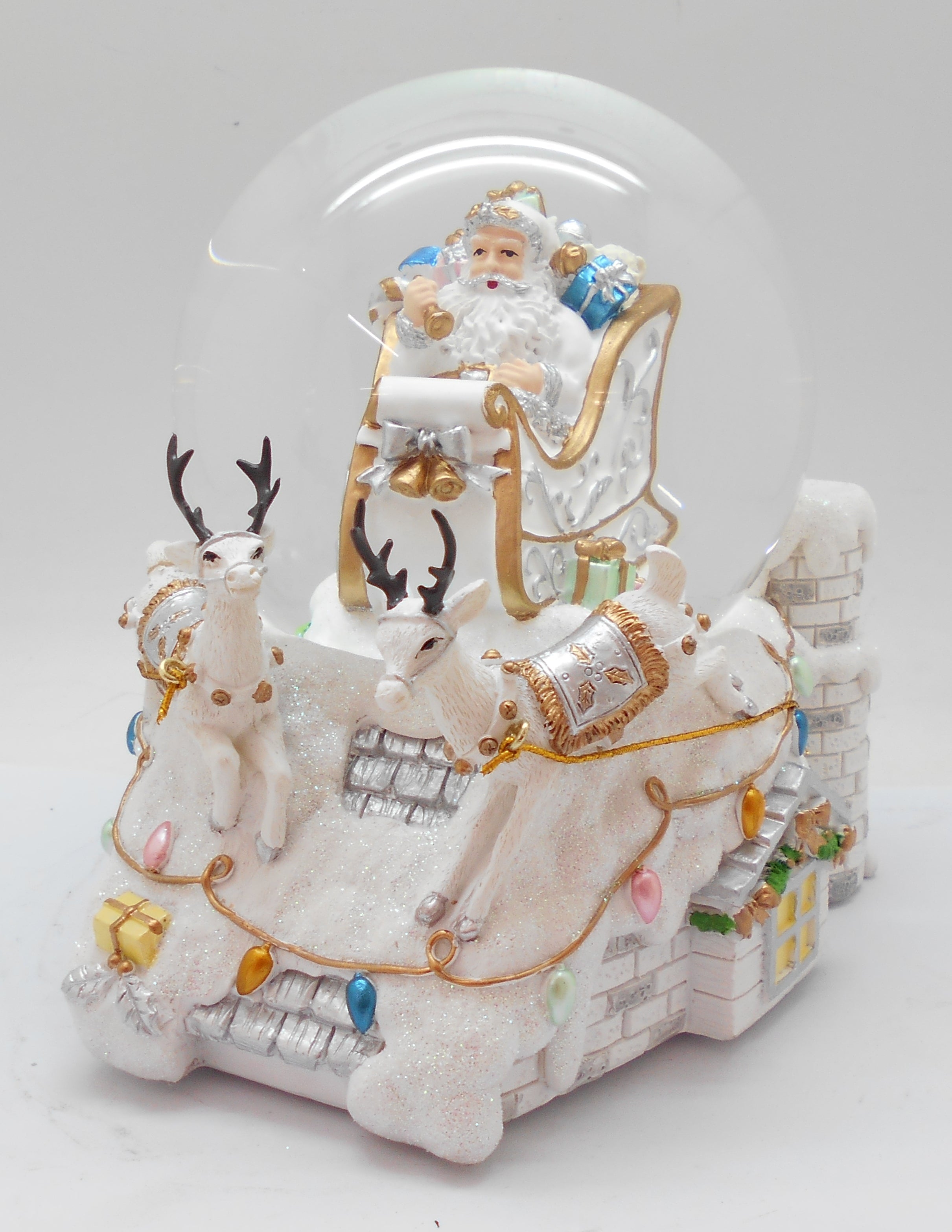 A snow globe featuring a figurine of Santa Claus seated on a reindeer-drawn sleigh with gifts.