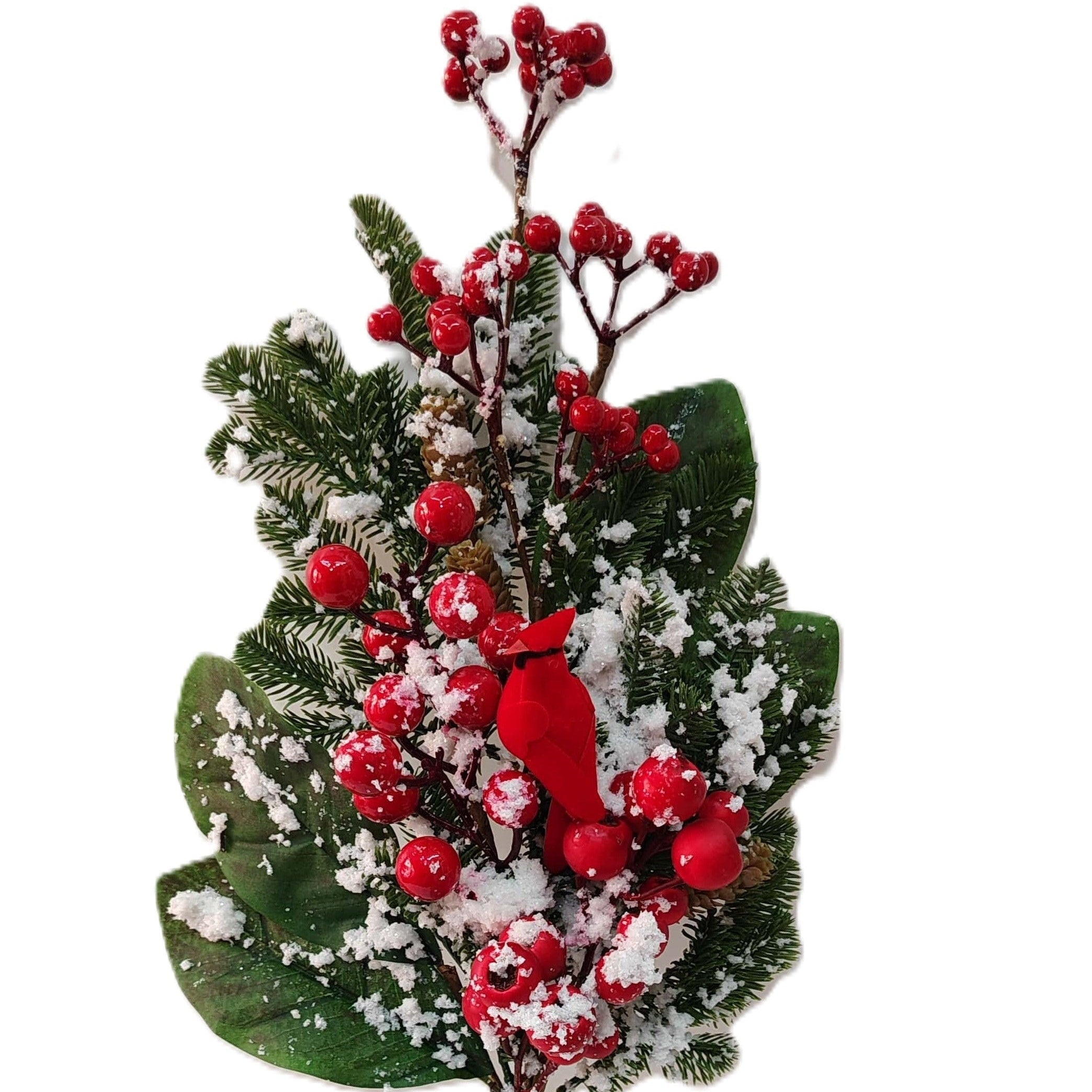 An artificial Christmas floral stem featuring green pine needles, large green leaves, bright red berries, and white faux snow, with a small red cardinal figurine in the center.