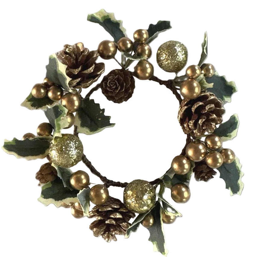 A decorative candle holder surrounded by gold pinecones, gold glittery ornaments, green holly leaves with cream edges, and gold berries.