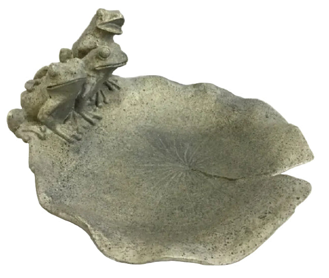 A decorative stone bowl shaped like a lily pad with three small frog sculptures perched along the left edge